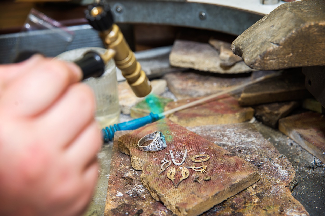a jeweler hand stamping on a ring