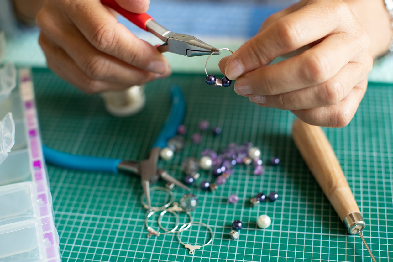 a woman crafting handmade metal jewelry 
