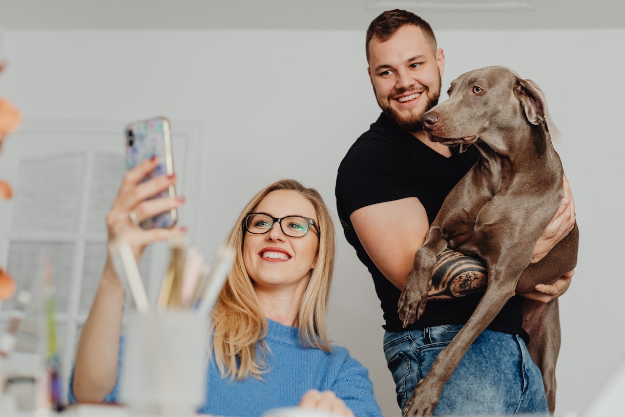 couple with a dog taking a selfie picture