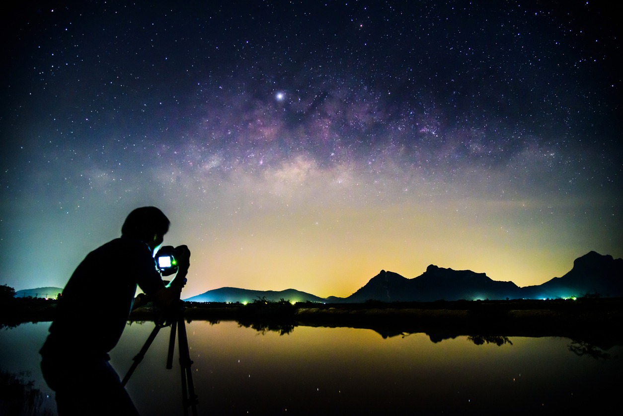 a photographer taking pictures of the night sky