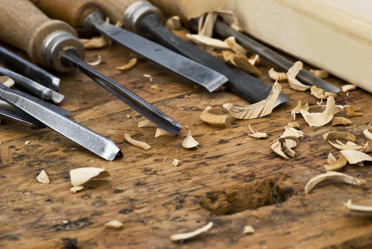 a variety of chisels on a craftsman’s bench