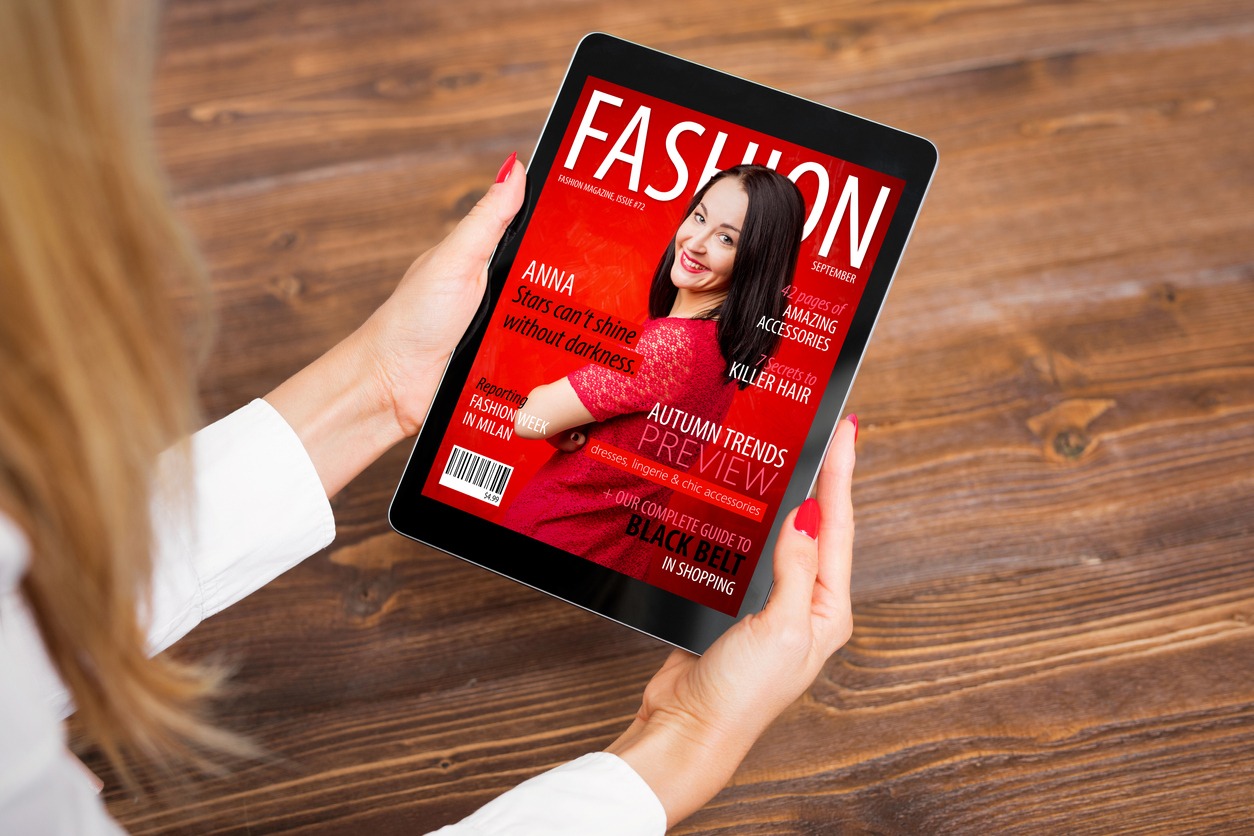 a woman reading a fashion magazine on tablet