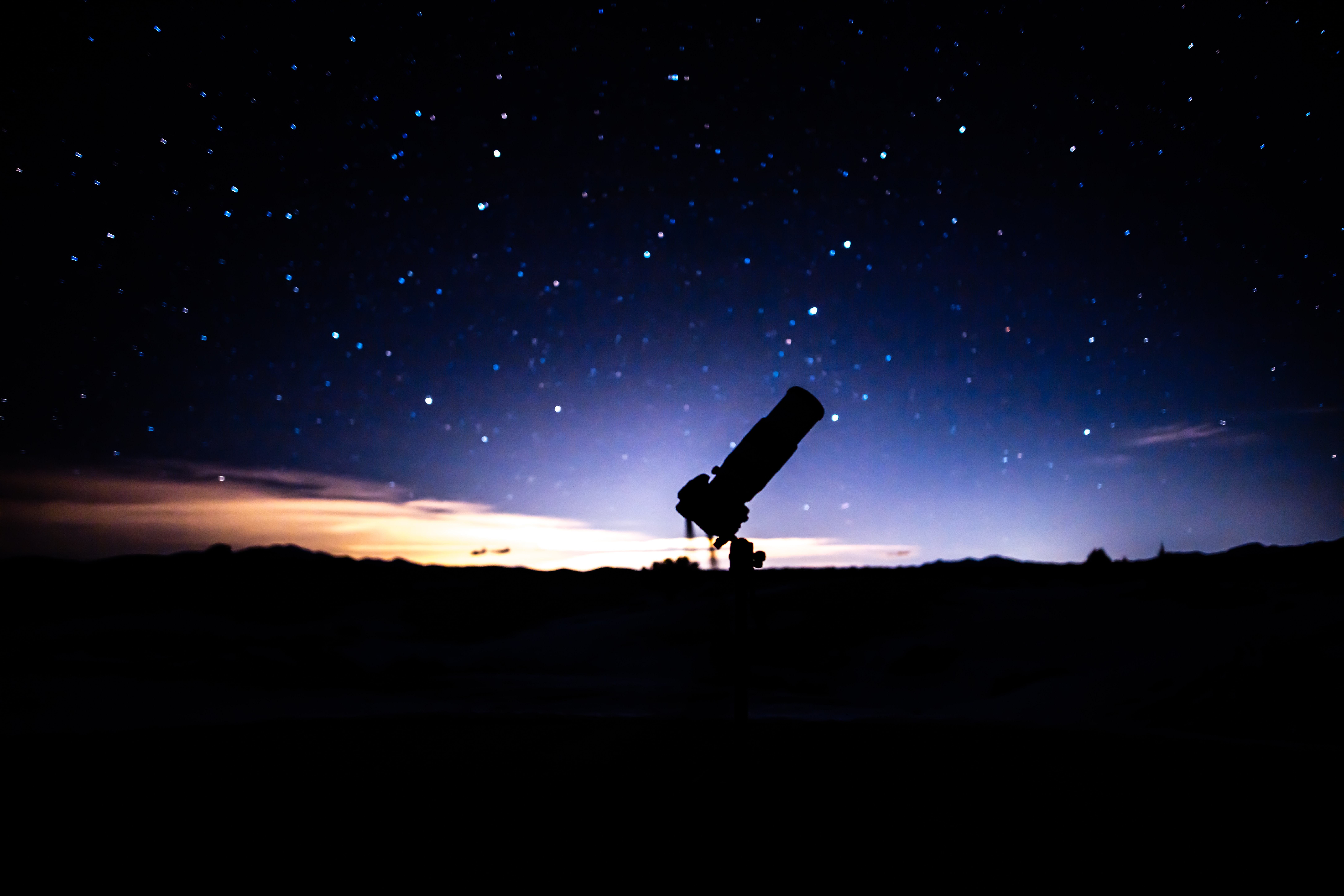 a-telescope-sitting-on-top-of-a-hill-under-a-night-sky
