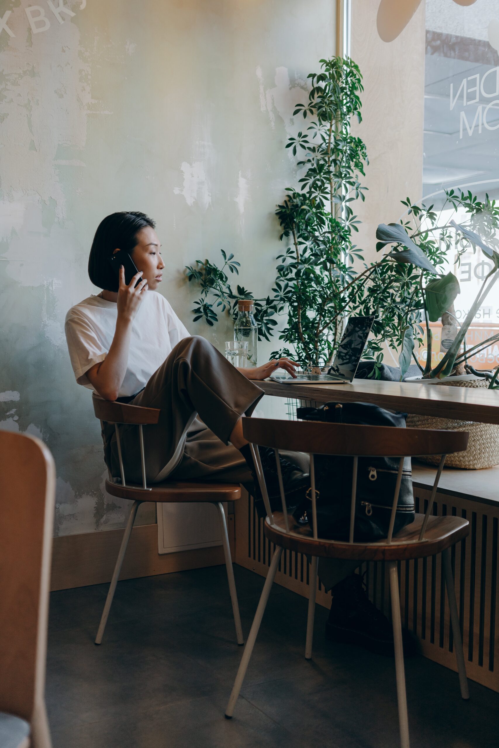 businesswoman-in-white-shirt-sitting-on-chair-while-having-phone-call