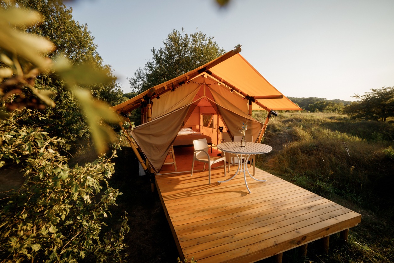 cozy-open-glamping-tent-with-light-inside-during-sunset-luxury-camping-tent