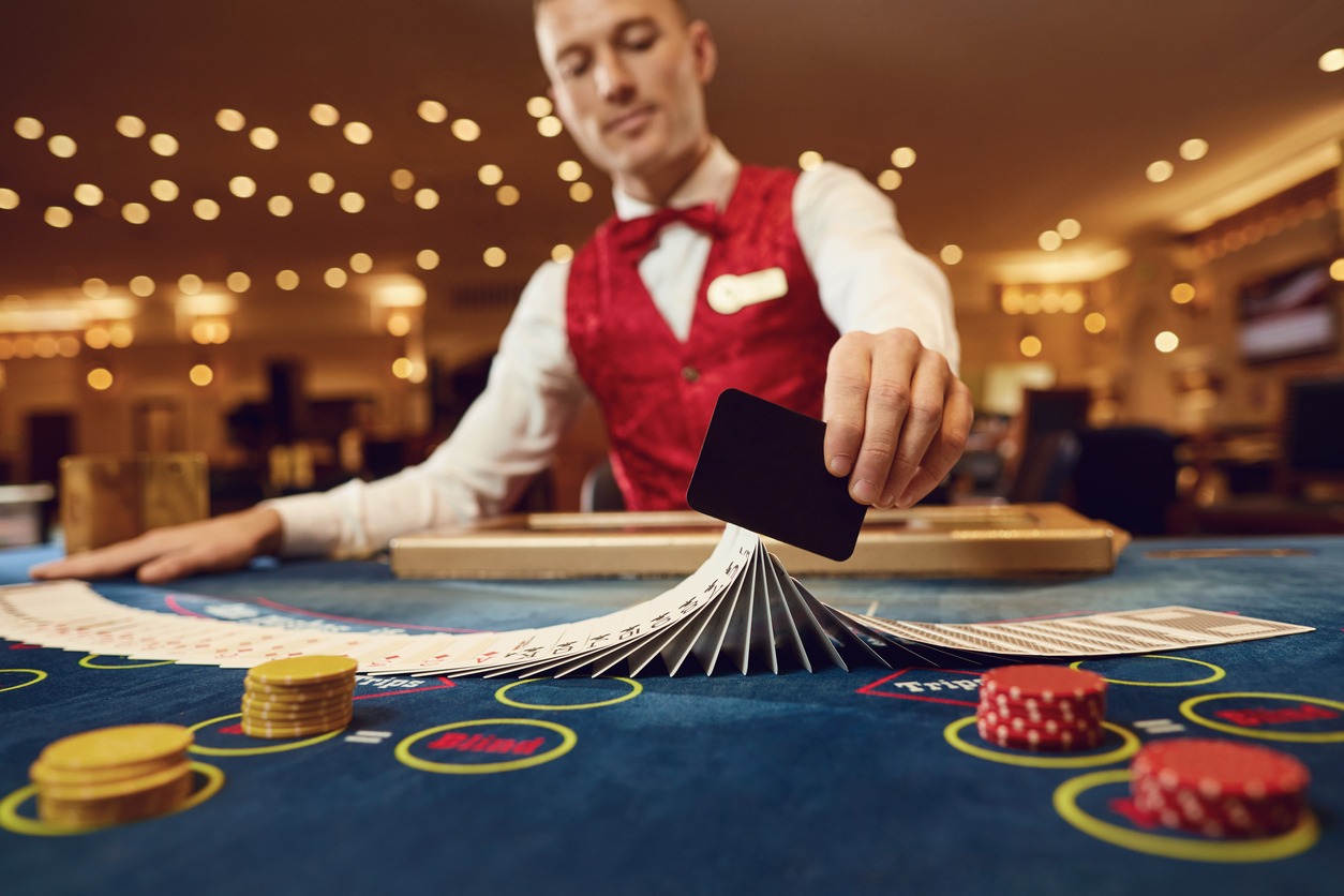 croupier-holds-poker-cards-in-his-hands-at-a-table-in-a-casino