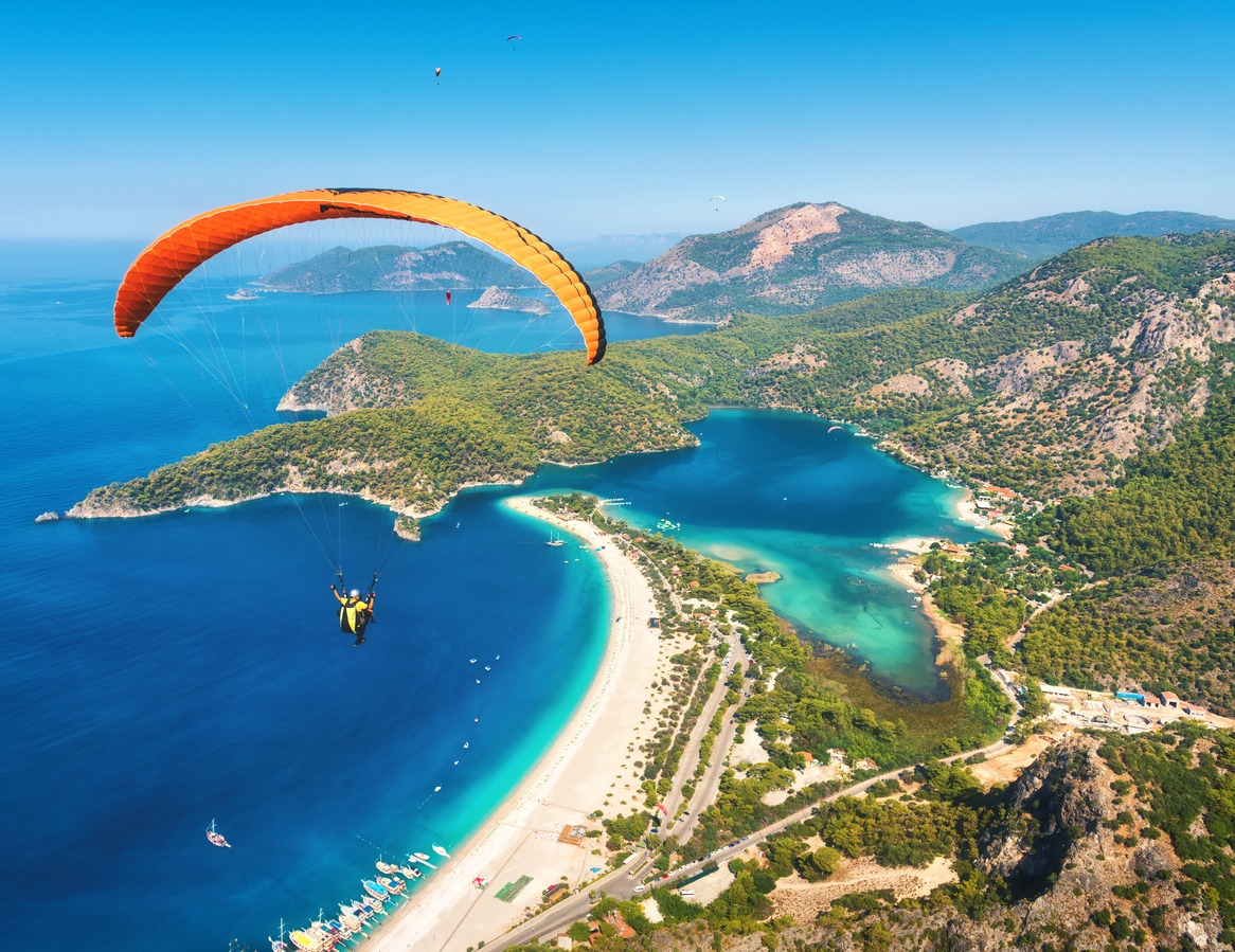 paragliding-in-the-sky-paraglider-tandem-flying-over-the-sea-with-blue-water