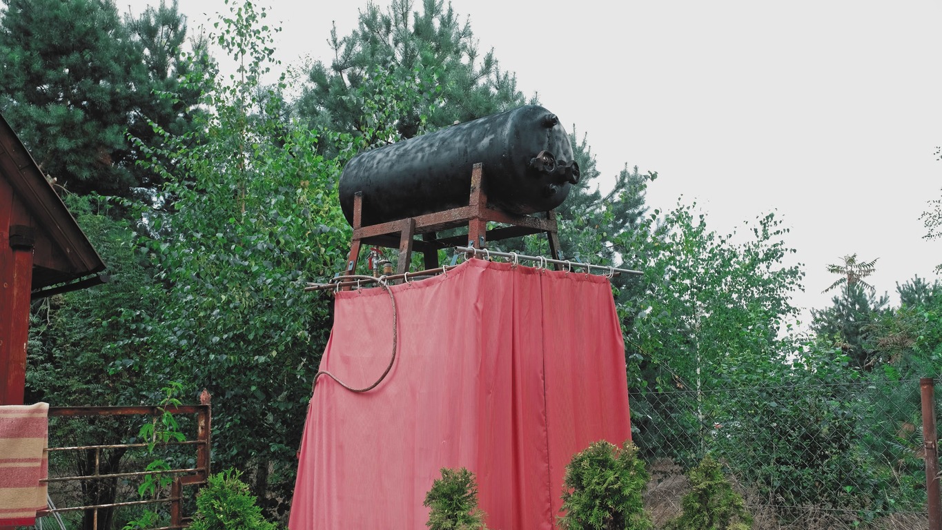 summer-camp-improvised-outdoor-shower-with-black-painted-water-tank