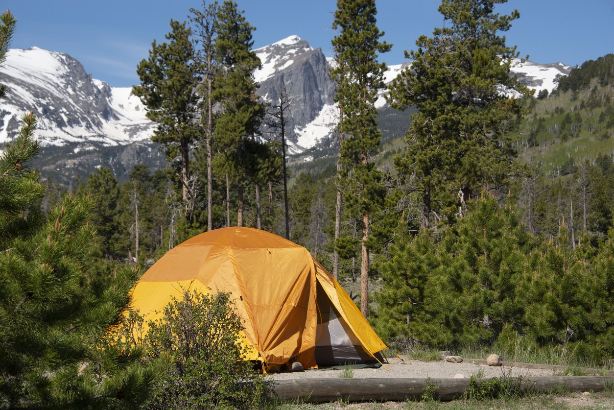 tenting-in-orange-tent-camping-with-hallet-peak-and-snow-covered-rocky-mountains