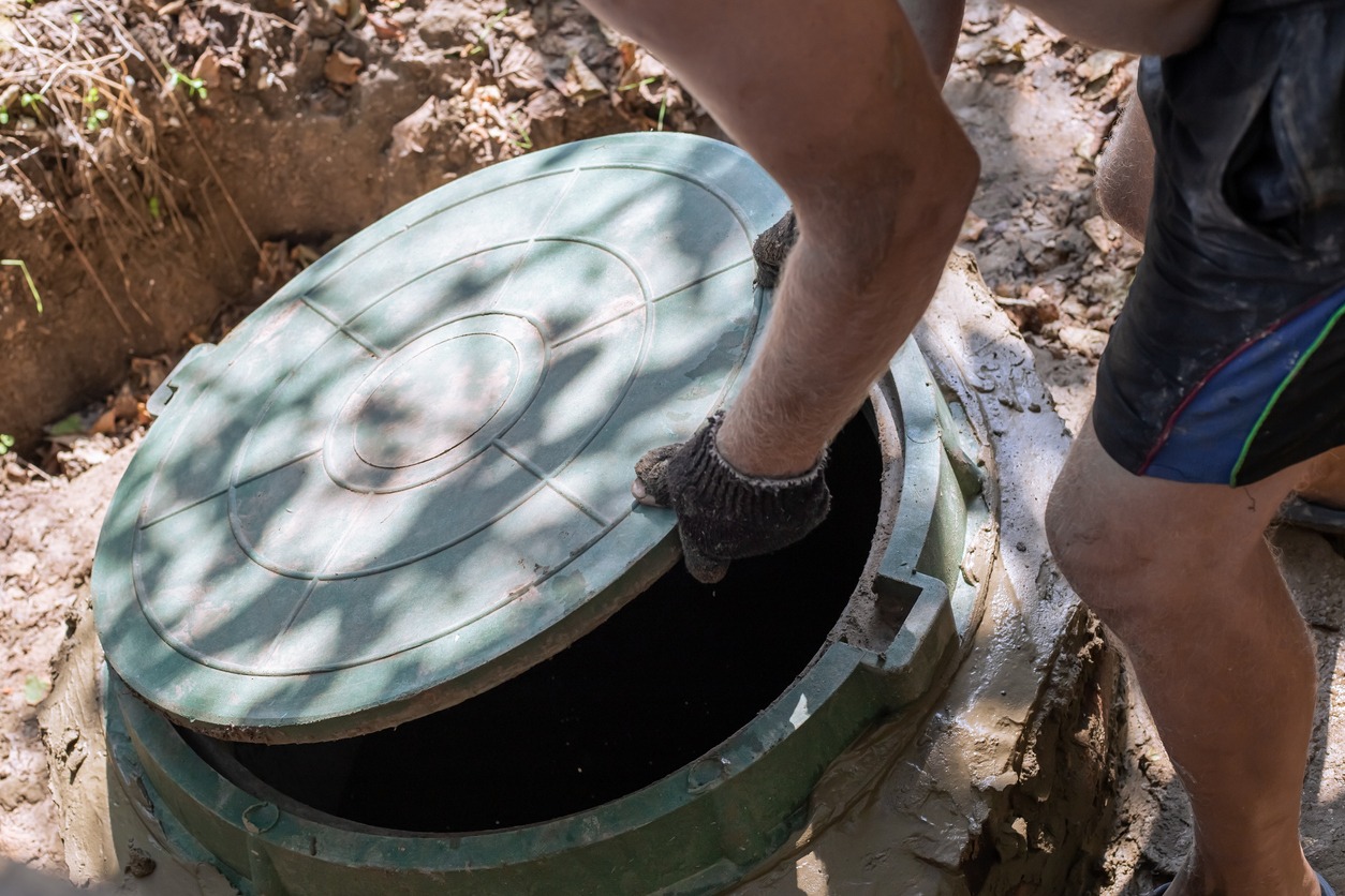 the-man-opens-the-sewer-hatch-installation-and-maintenance
