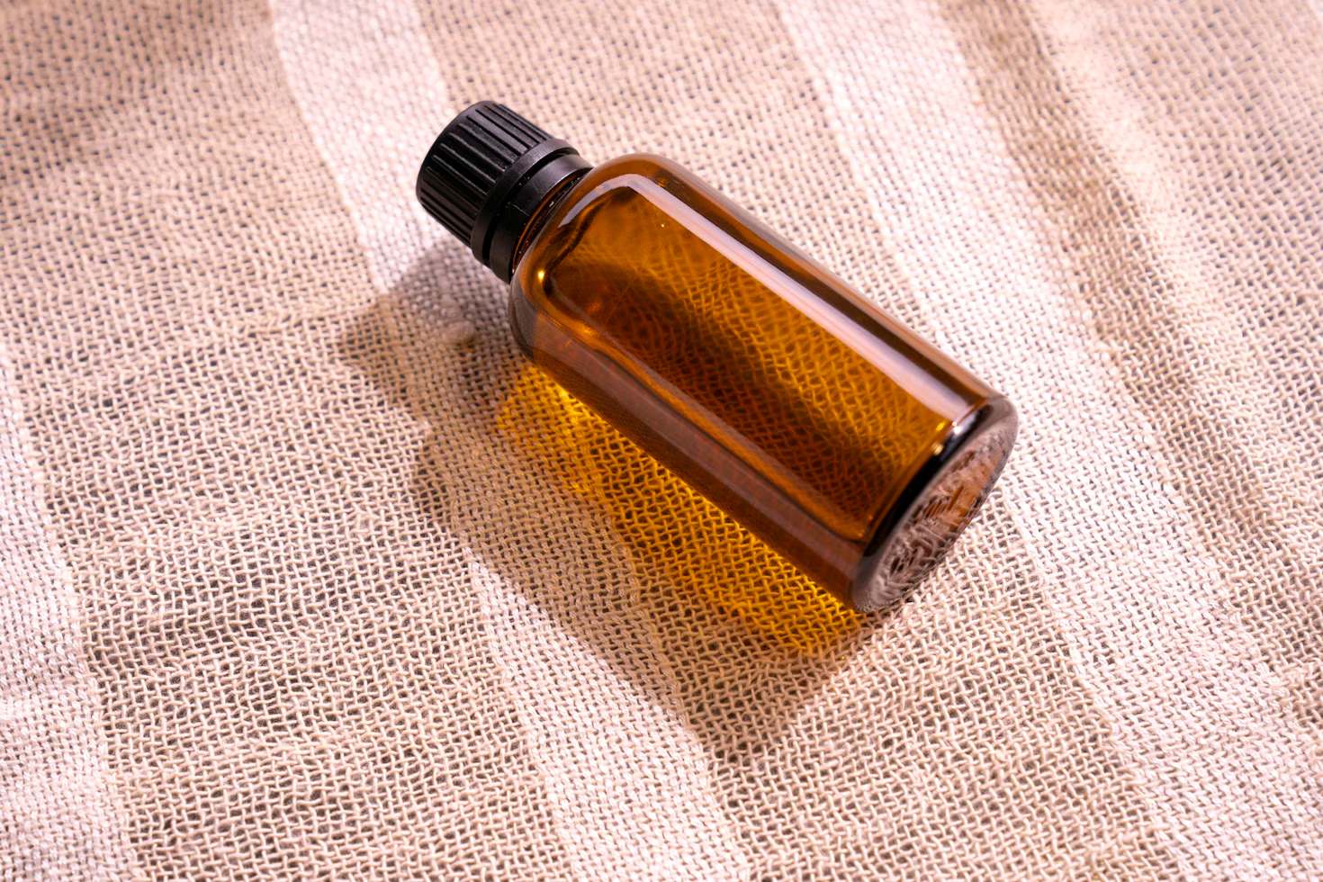 A bottle of essential oil sitting on a cloth