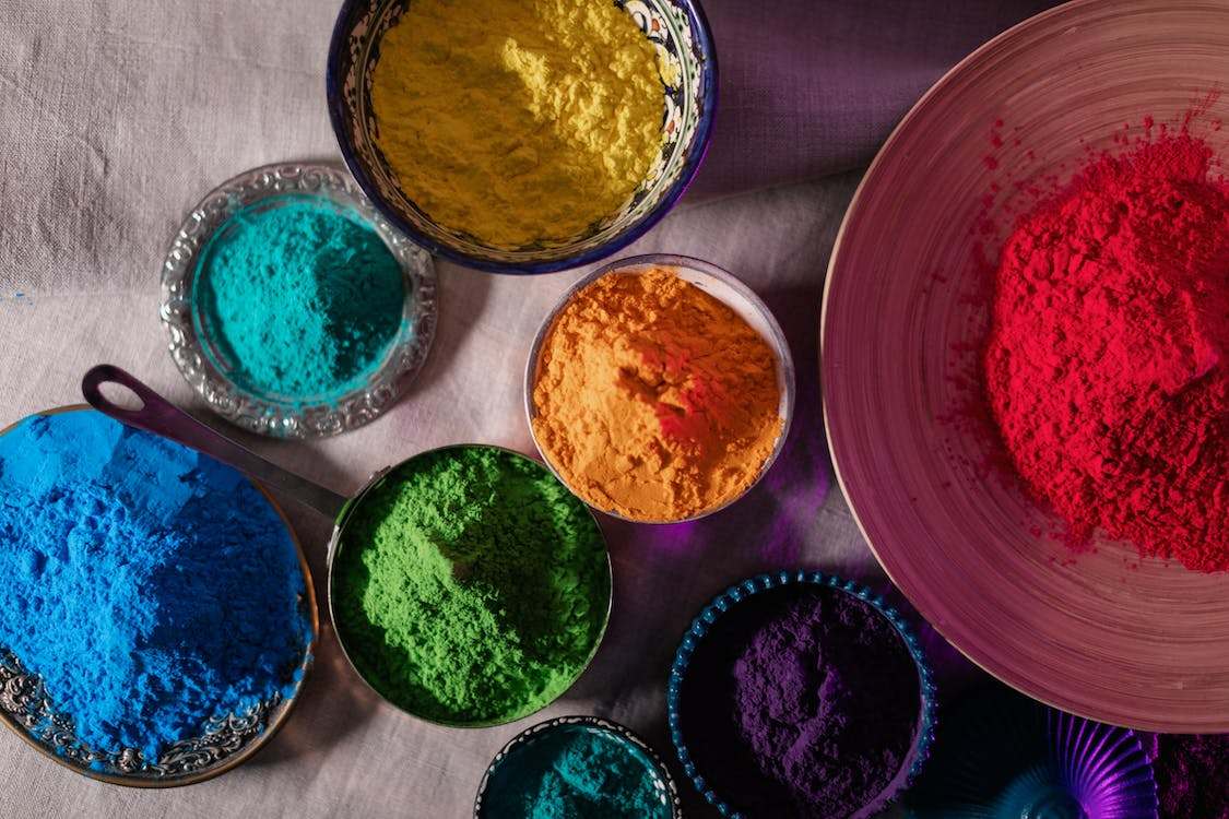 Top view of multicolored powders in bowls and plates
