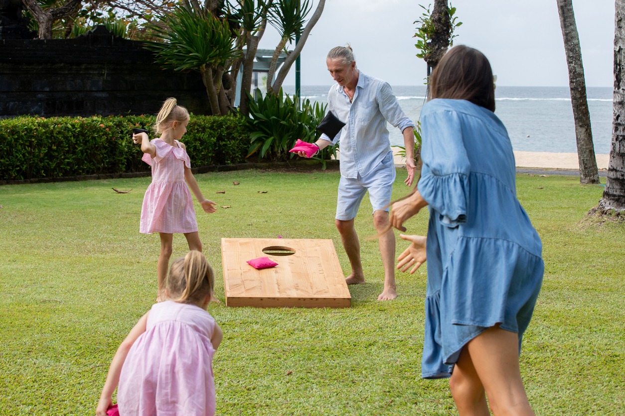 Happy family playing cornhole game